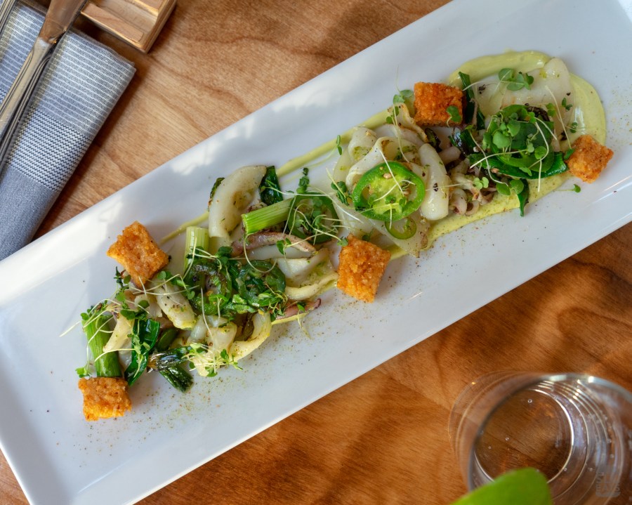 A photo of a plate of grilled calamari with fried rice and jalapeños
